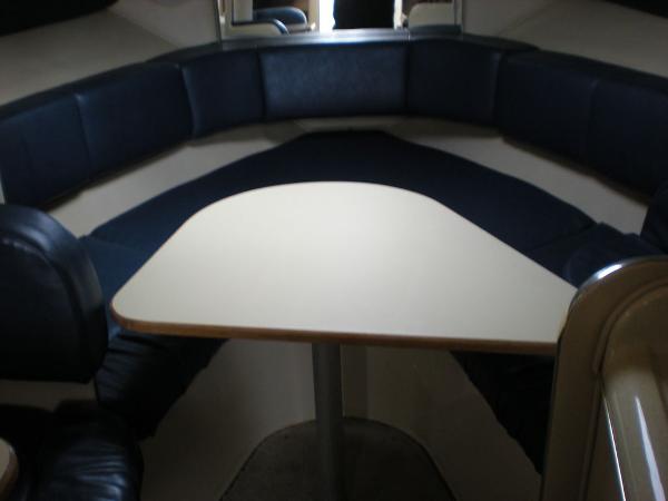Slide: The Image of 1998 Sea Ray Sundancer 270 interior cabin with dining table and cushioned seating. - 9