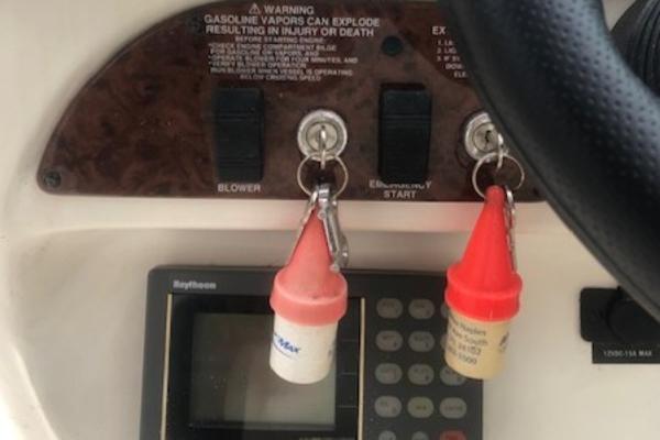 Slide: The Image of Control panel of a 2000 Sea Ray 280 Bow Rider boat with keys and warning labels. - 11