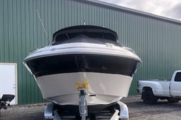 Slide: The Image of 2000 Sea Ray 280 Bow Rider on trailer, parked beside a green building and white truck. - 2