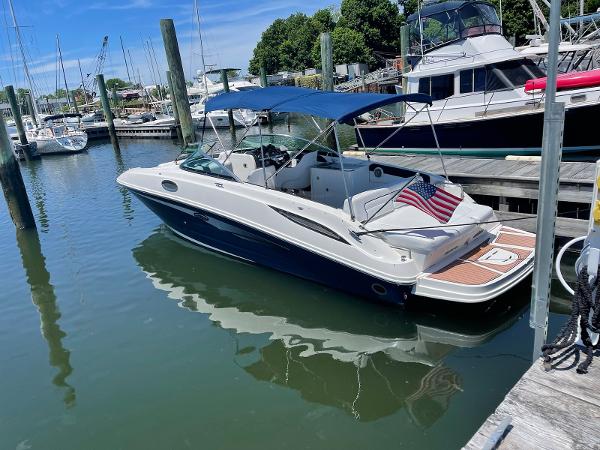 Slide: The Image of 2014 Sea Ray 280 Sundeck boat docked at a marina with an American flag. - 0