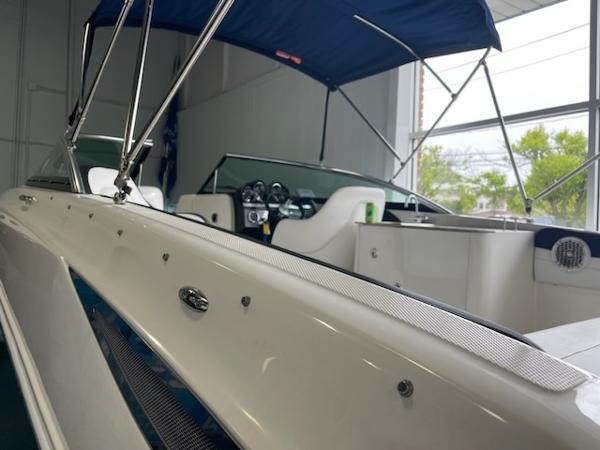 Slide: The Image of 2014 Sea Ray 280 Sundeck boat with blue canopy in a showroom. - 9
