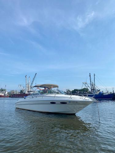 Slide: The Image of 1999 Sea Ray 280 Sun Sport boat anchored in a calm harbor. - 0