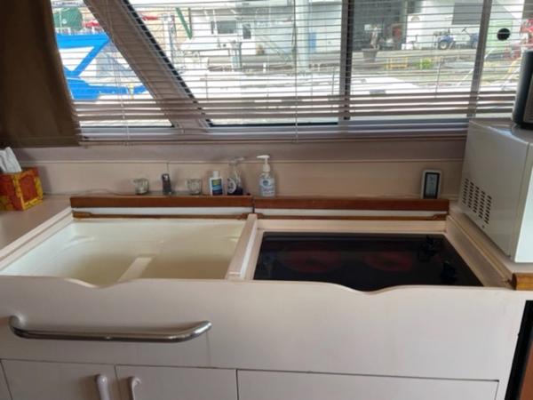 Slide: The Image of 1989 Sea Ray 300 Sedan Bridge kitchen with sink, stove, and microwave. - 19