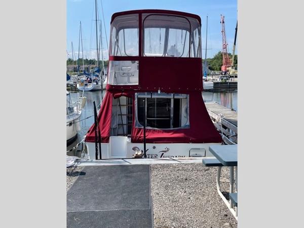 Slide: The Image of 1989 Sea Ray 300 Sedan Bridge docked at marina with red canopy. - 3