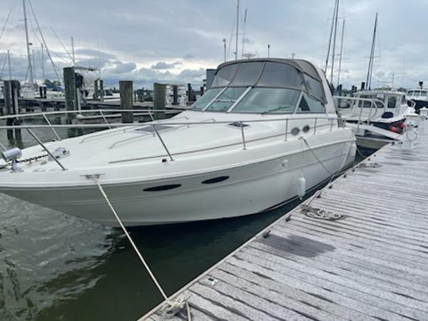 Slide: The Image of 1999 Sea Ray 310 Sundancer docked at marina on a cloudy day. - 0