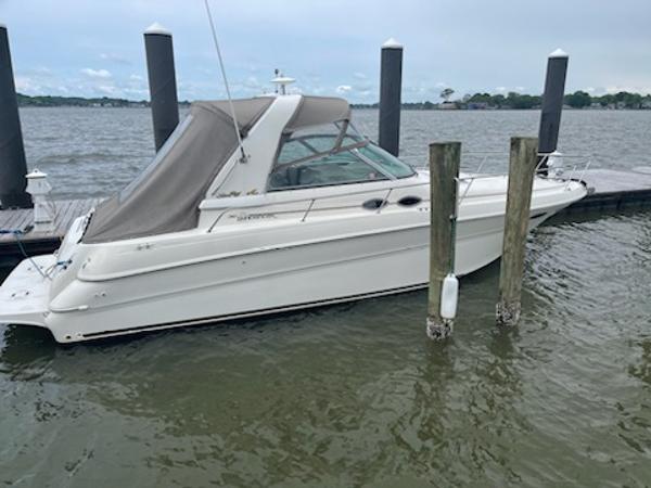 Slide: The Image of 1999 Sea Ray 310 Sundancer docked at a marina. - 1