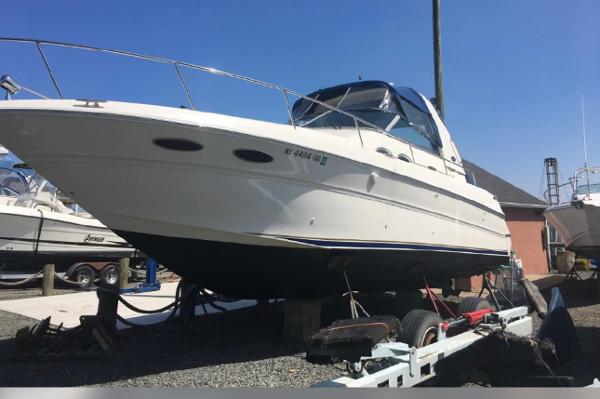 Slide: The Image of 2002 Sea Ray 310 Sundancer boat on a trailer in a marina. - 11