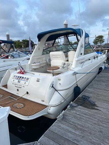 Slide: The Image of 2002 Sea Ray 310 Sundancer docked, rear view with seating and canopy. - 2