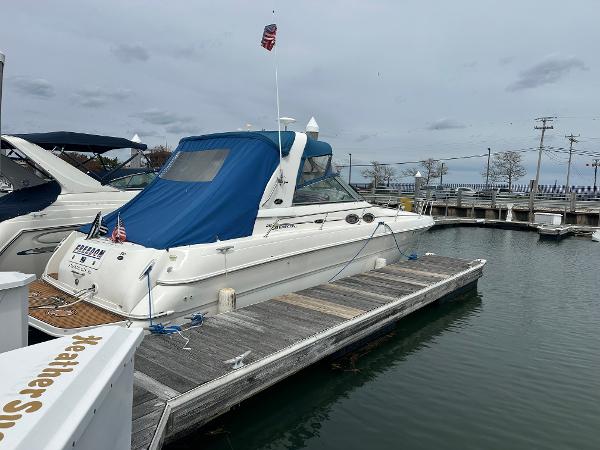 Slide: The Image of 2002 Sea Ray 310 Sundancer docked at a marina with blue canvas cover. - 3