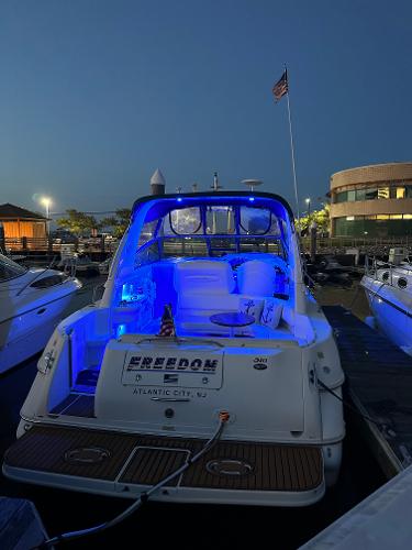 Slide: The Image of 2002 Sea Ray 310 Sundancer docked at night with blue interior lights. - 9
