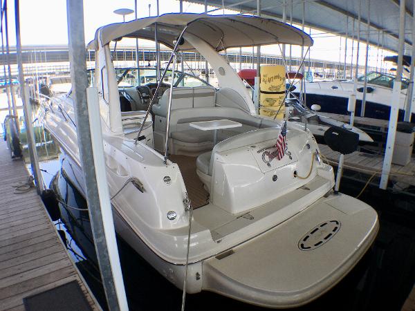 Slide: The Image of 2002 Sea Ray 320 Sundancer yacht docked in a marina, rear view. - 1