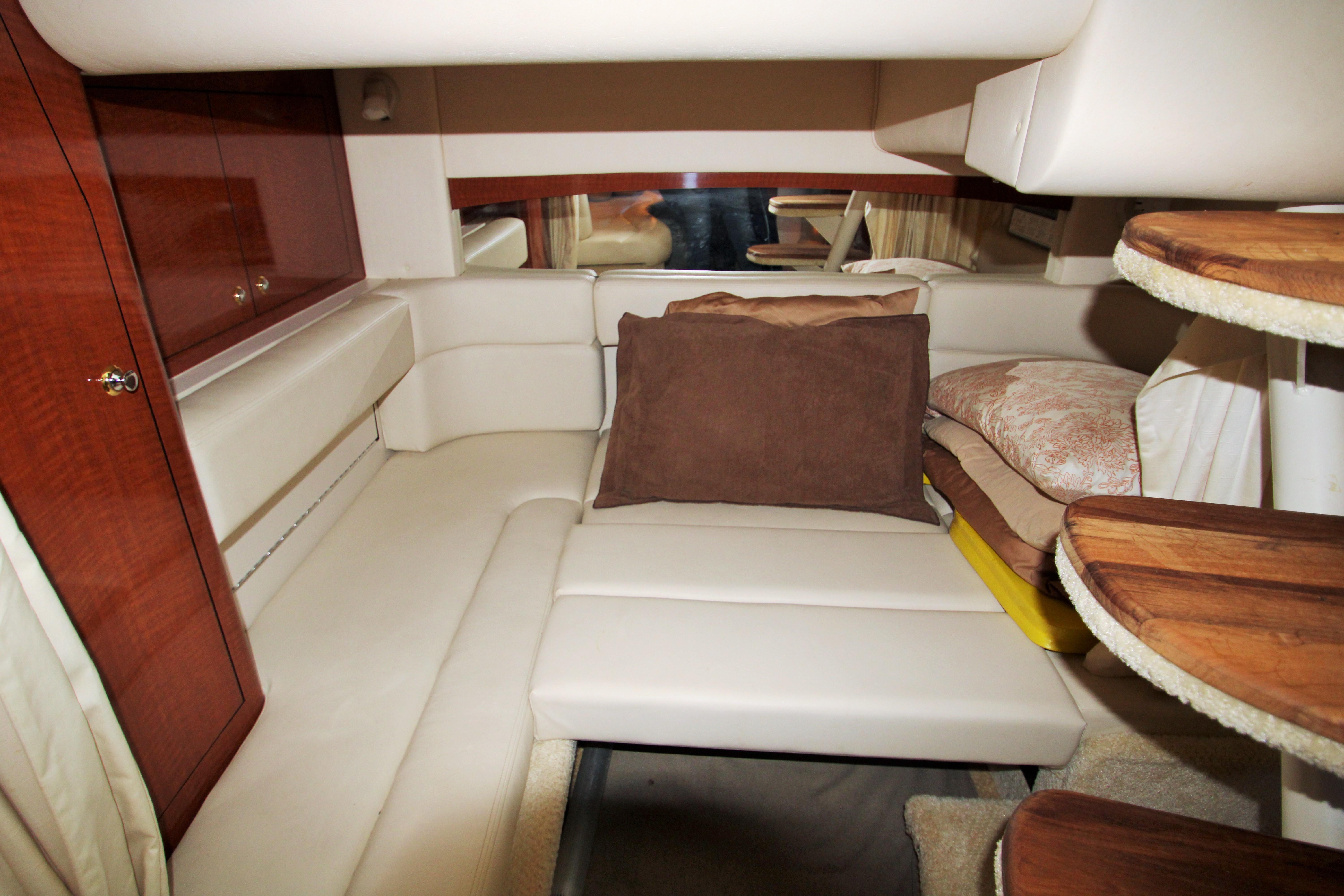 Slide: The Image of Interior cabin of 2003 Sea Ray 320 Sundancer with cozy seating and wooden accents. - 17