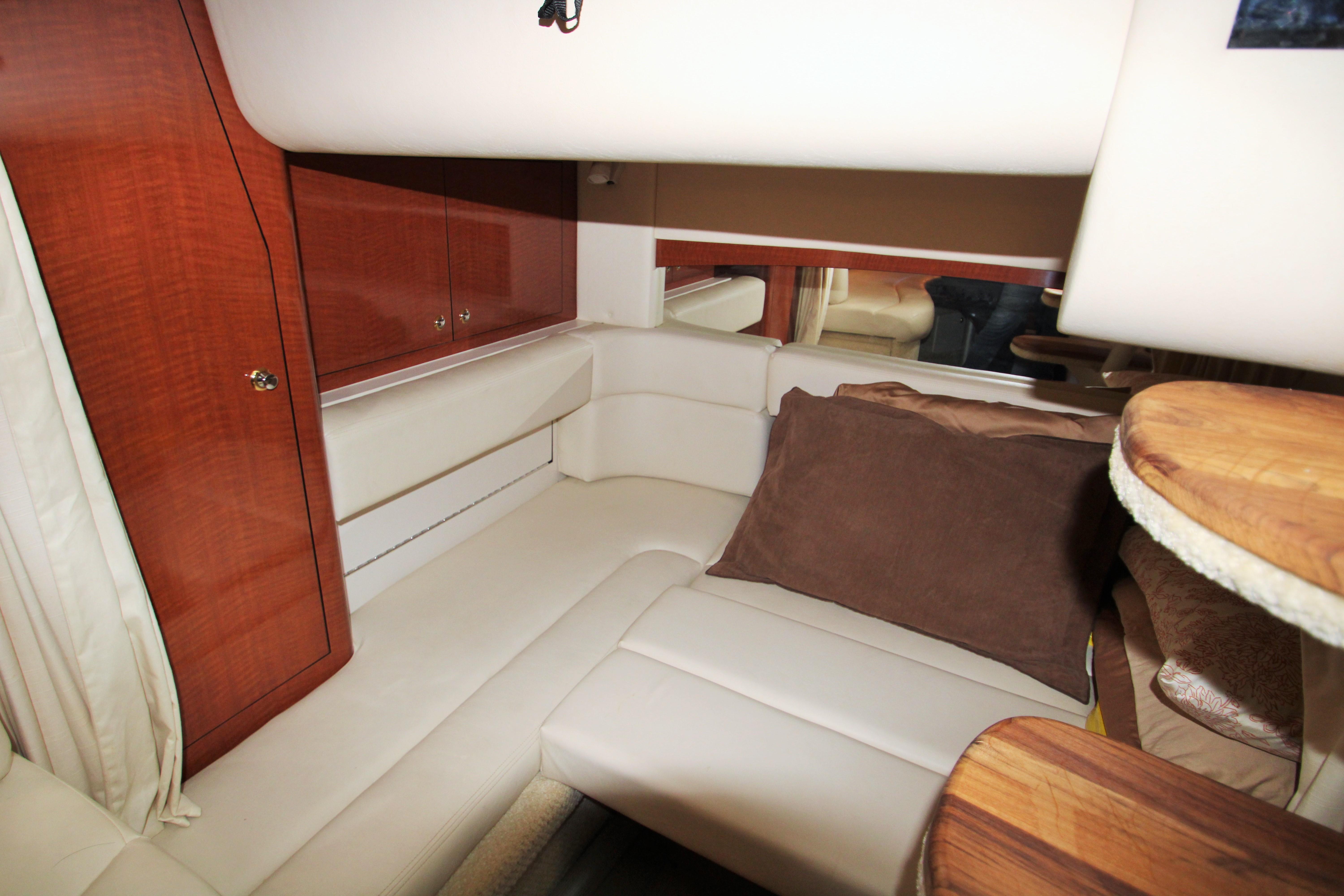 Slide: The Image of Interior of 2003 Sea Ray 320 Sundancer with cream seating and wooden cabinetry. - 21