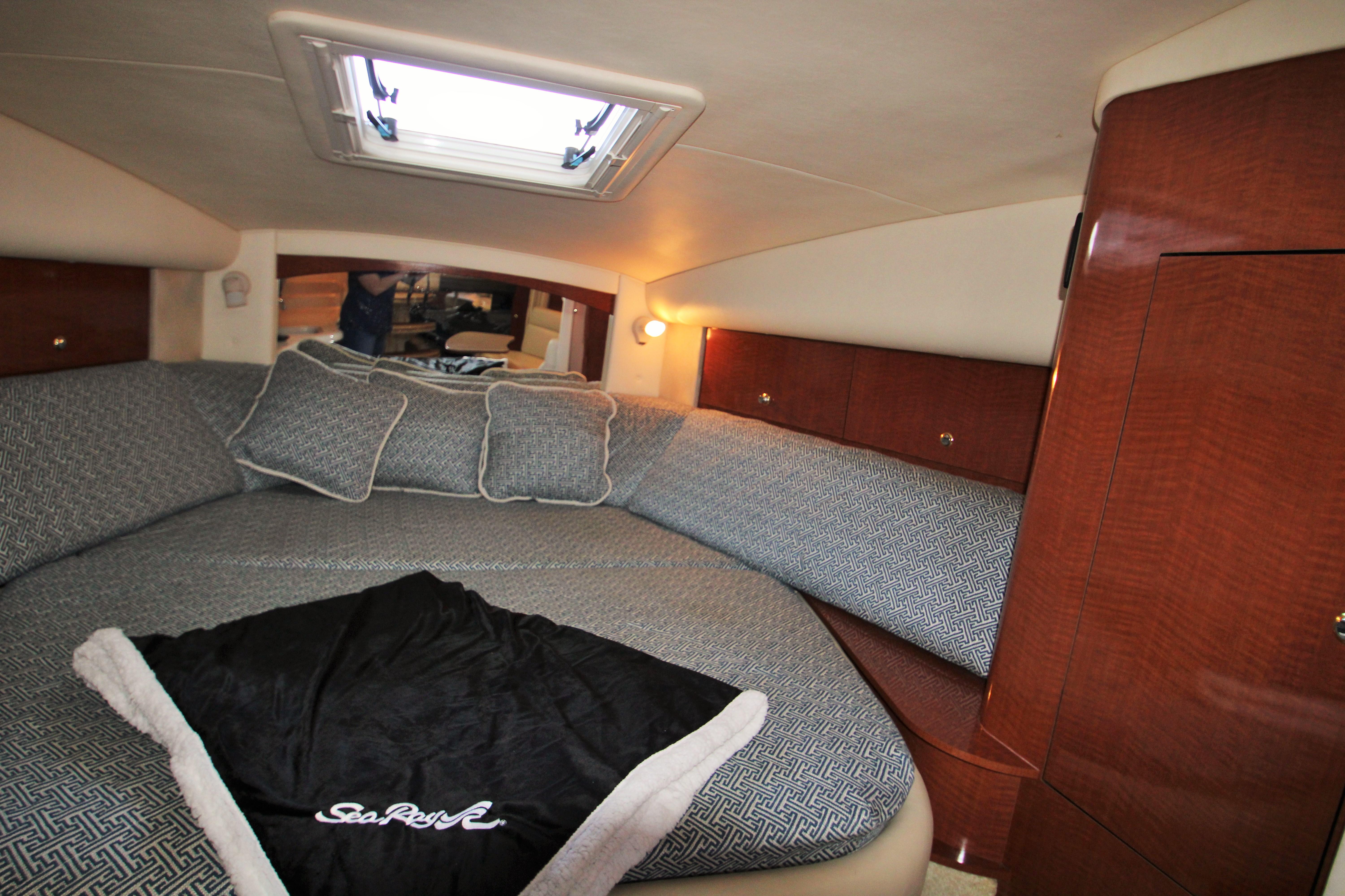 Slide: The Image of Luxurious cabin interior of 2003 Sea Ray 320 Sundancer with cozy bedding and wood accents. - 7