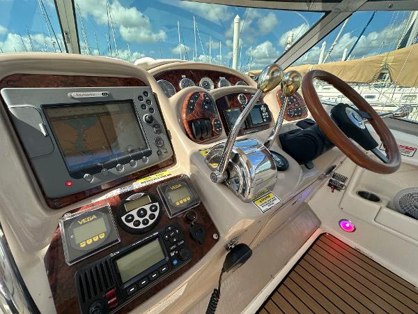 Slide: The Image of 2004 Sea Ray 320 Sundancer helm with navigation equipment and controls. - 21