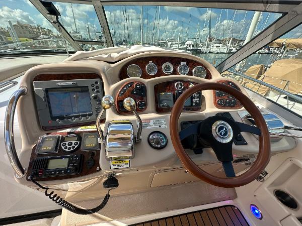 Slide: The Image of 2004 Sea Ray 320 Sundancer helm with navigation equipment and steering wheel. - 22