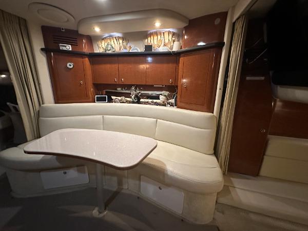 Slide: The Image of 2004 Sea Ray 320 Sundancer cabin interior with dining area and kitchenette. - 30