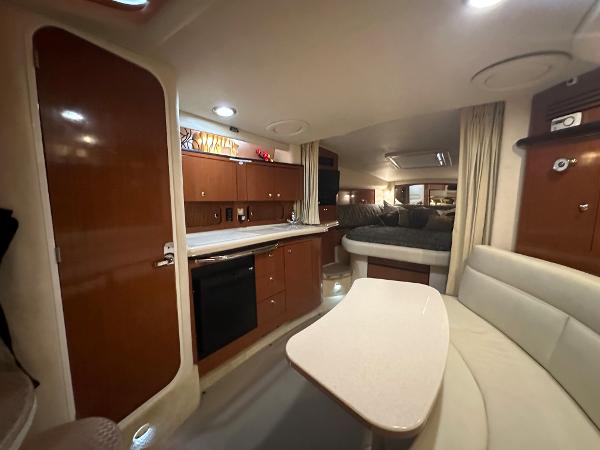 Slide: The Image of 2004 Sea Ray 320 Sundancer interior with kitchen, dining area, and sleeping quarters. - 31