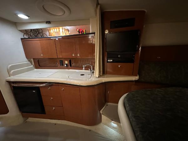 Slide: The Image of 2004 Sea Ray 320 Sundancer interior with kitchenette and seating area. - 34