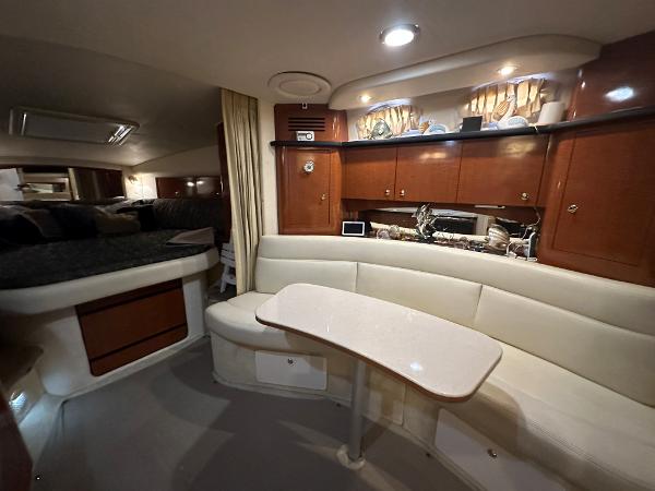 Slide: The Image of Interior of 2004 Sea Ray 320 Sundancer yacht with dining area and kitchenette. - 35