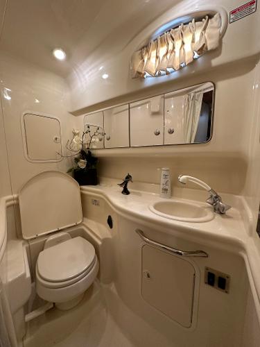 Slide: The Image of 2004 Sea Ray 320 Sundancer bathroom with sink, toilet, and storage cabinets. - 39