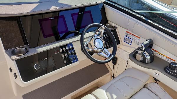 Slide: The Image of Interior helm of 2021 Sea Ray 320 Sundancer with modern controls and steering wheel. - 14