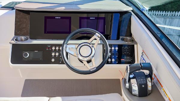 Slide: The Image of 2021 Sea Ray 320 Sundancer helm with modern controls and dual displays. - 15