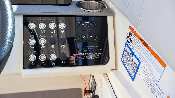 Slide: The Image of Control panel of 2021 Sea Ray 320 Sundancer boat with warning labels and cup holder. - 20