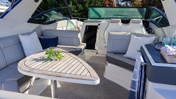 Slide: The Image of Luxurious 2021 Sea Ray 320 Sundancer interior with elegant seating and wooden table. - 24