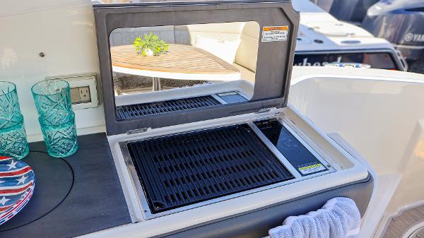 Slide: The Image of Outdoor grill on 2021 Sea Ray 320 Sundancer yacht with glassware and towel. - 28