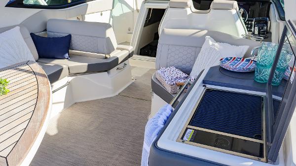 Slide: The Image of Luxurious 2021 Sea Ray 320 Sundancer interior with seating and kitchenette. - 29