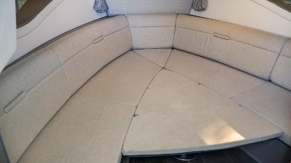 Slide: The Image of 2021 Sea Ray 320 Sundancer interior seating area with beige upholstery. - 32