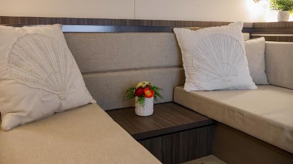 Slide: The Image of Interior of 2021 Sea Ray 320 Sundancer with beige seating and decorative pillows. - 37