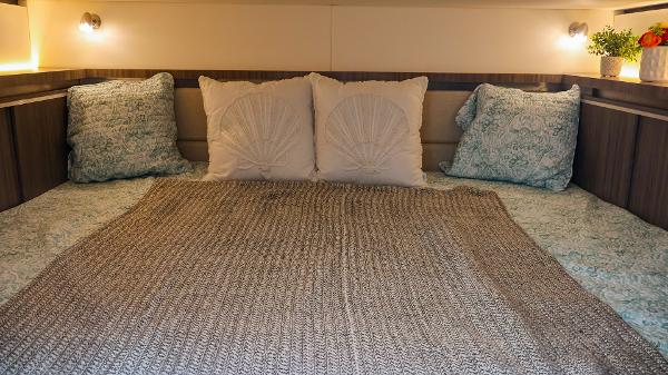 Slide: The Image of Cozy cabin interior of 2021 Sea Ray 320 Sundancer with plush bedding and ambient lighting. - 38