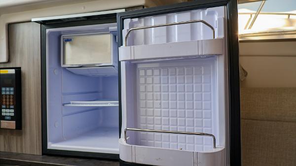 Slide: The Image of Open refrigerator inside 2021 Sea Ray 320 Sundancer yacht cabin. - 42