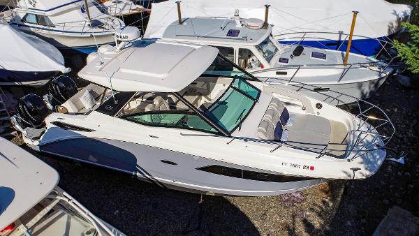 Slide: The Image of 2021 Sea Ray 320 Sundancer boat docked among other vessels. - 5