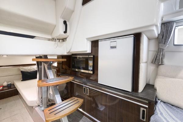 Slide: The Image of Interior of 2023 Sea Ray Sundancer 320 yacht with kitchenette and seating area. - 11
