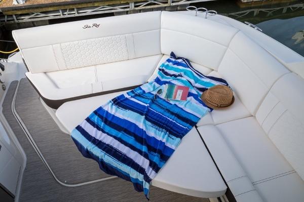 Slide: The Image of Sea Ray Sundancer 320 2023 boat with white seating, striped towel, book, and hat. - 17