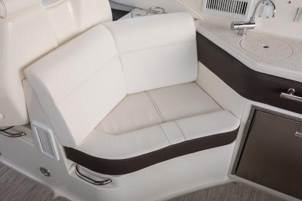 Slide: The Image of 2023 Sea Ray Sundancer 320 interior seating area with white and brown upholstery. - 19
