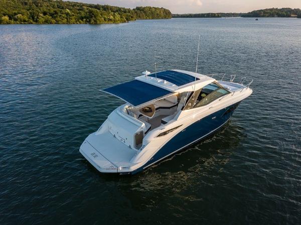 Slide: The Image of 2023 Sea Ray Sundancer 320 yacht cruising on a serene lake. - 5