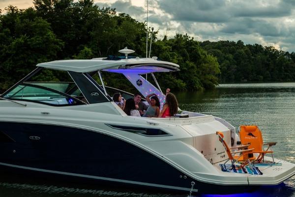 Slide: The Image of 2023 Sea Ray Sundancer 320 cruising on a lake with passengers enjoying the view. - 7