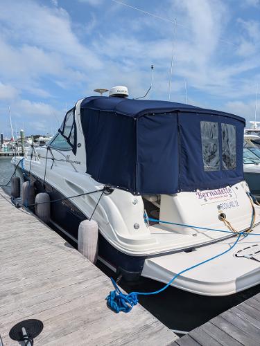 Slide: The Image of 2004 Sea Ray 360 Sundancer docked with blue canopy, clear sky background. - 0