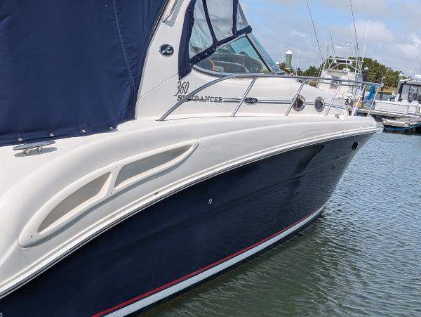 Slide: The Image of 2004 Sea Ray 360 Sundancer yacht docked in marina, featuring sleek design and blue hull. - 1