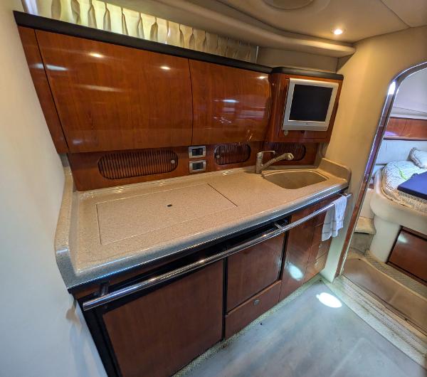 Slide: The Image of 2004 Sea Ray 360 Sundancer yacht interior with kitchenette, sink, and TV. - 13