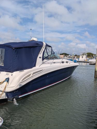 Slide: The Image of 2004 Sea Ray 360 Sundancer yacht docked in a marina under a partly cloudy sky. - 2