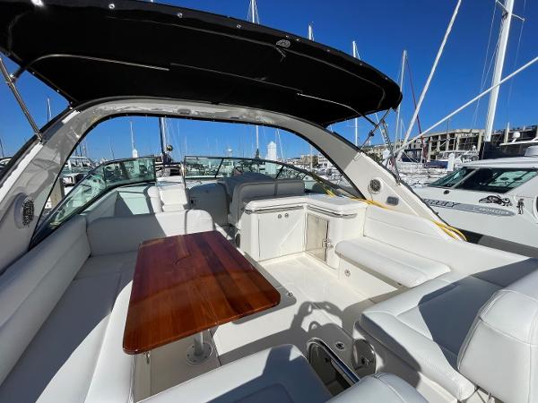 Slide: The Image of 2015 Sea Ray 370 Venture yacht interior with white seating and wooden table. - 12