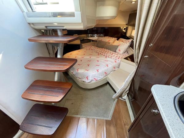 Slide: The Image of Interior cabin of a 2015 Sea Ray 370 Venture with bed and wooden steps. - 37