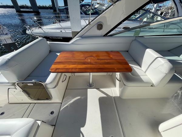 Slide: The Image of 2015 Sea Ray 370 Venture boat interior with wooden table and white seating. - 5