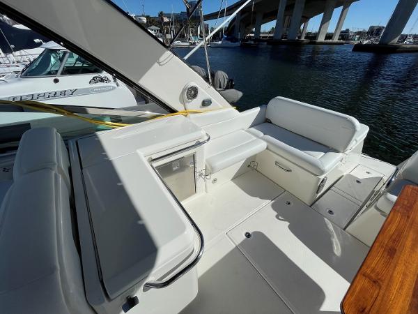 Slide: The Image of 2015 Sea Ray 370 Venture boat deck with seating and storage, docked near a marina. - 9