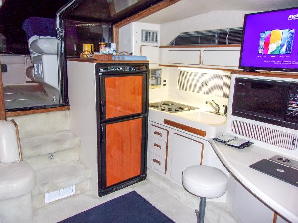 Slide: The Image of Interior of 1992 Sea Ray 400 Express Cruiser with kitchen and seating area. - 12